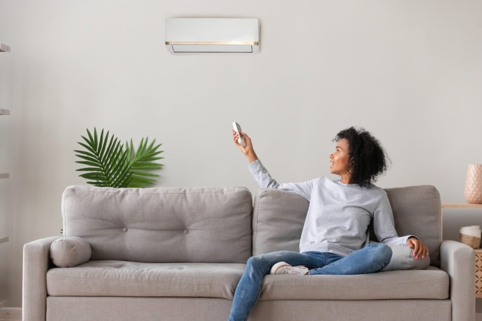 Smiling,Young,African,American,Woman,Using,Air,Conditioner,,Cooler,System
