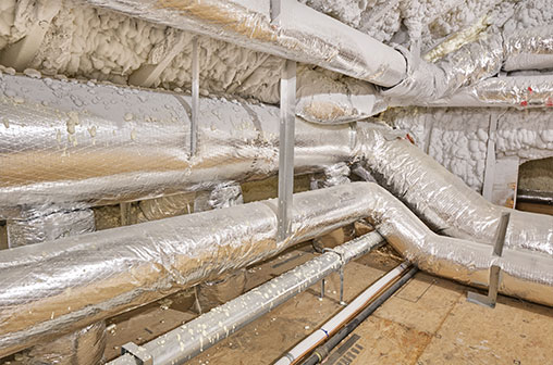 A maze of air conditioning and heating ducts running through an attic space